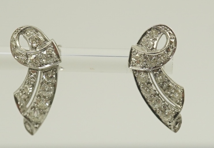 A pair of 18ct white gold and millegrain set diamond cluster scroll earrings